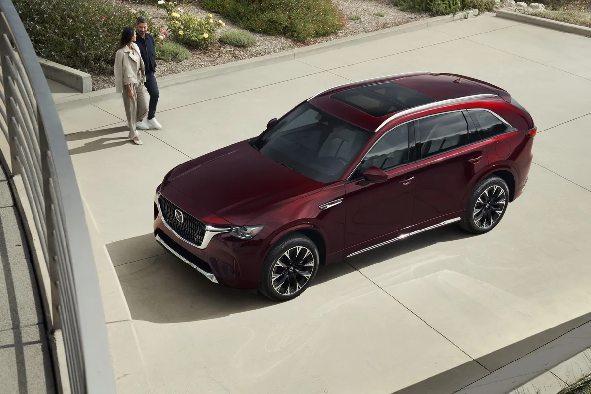 Mazda CX-90 in Artisan Red parked beside a building
