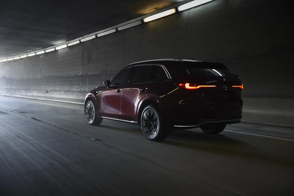 Mazda CX-90 in Artisan Red, rear three-quarter view in a tunnel