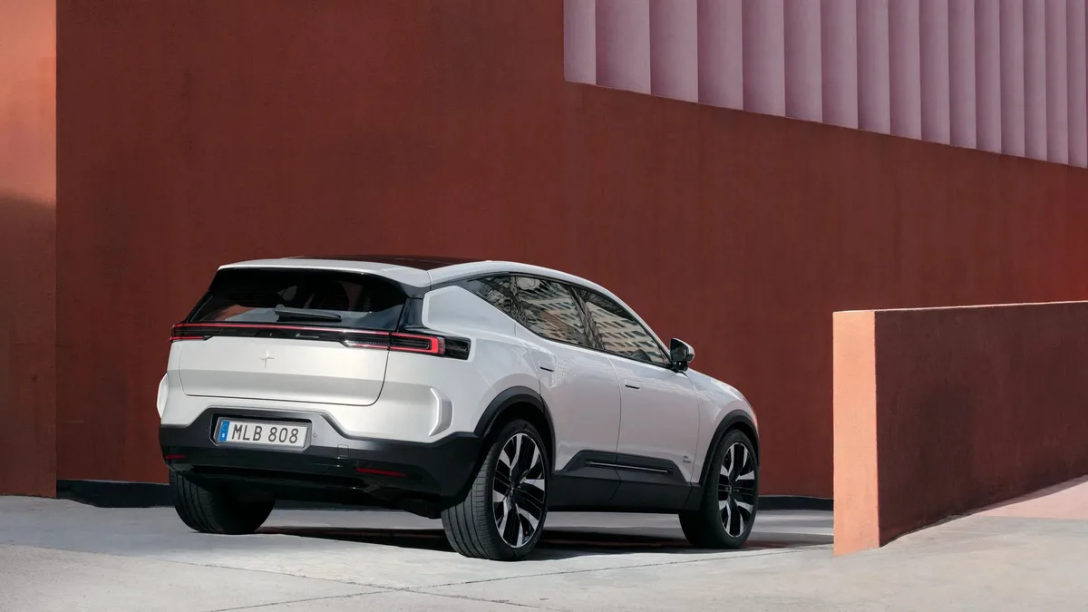 Polestar 3 in white parked beside a terracotta wall, rear three-quarter view