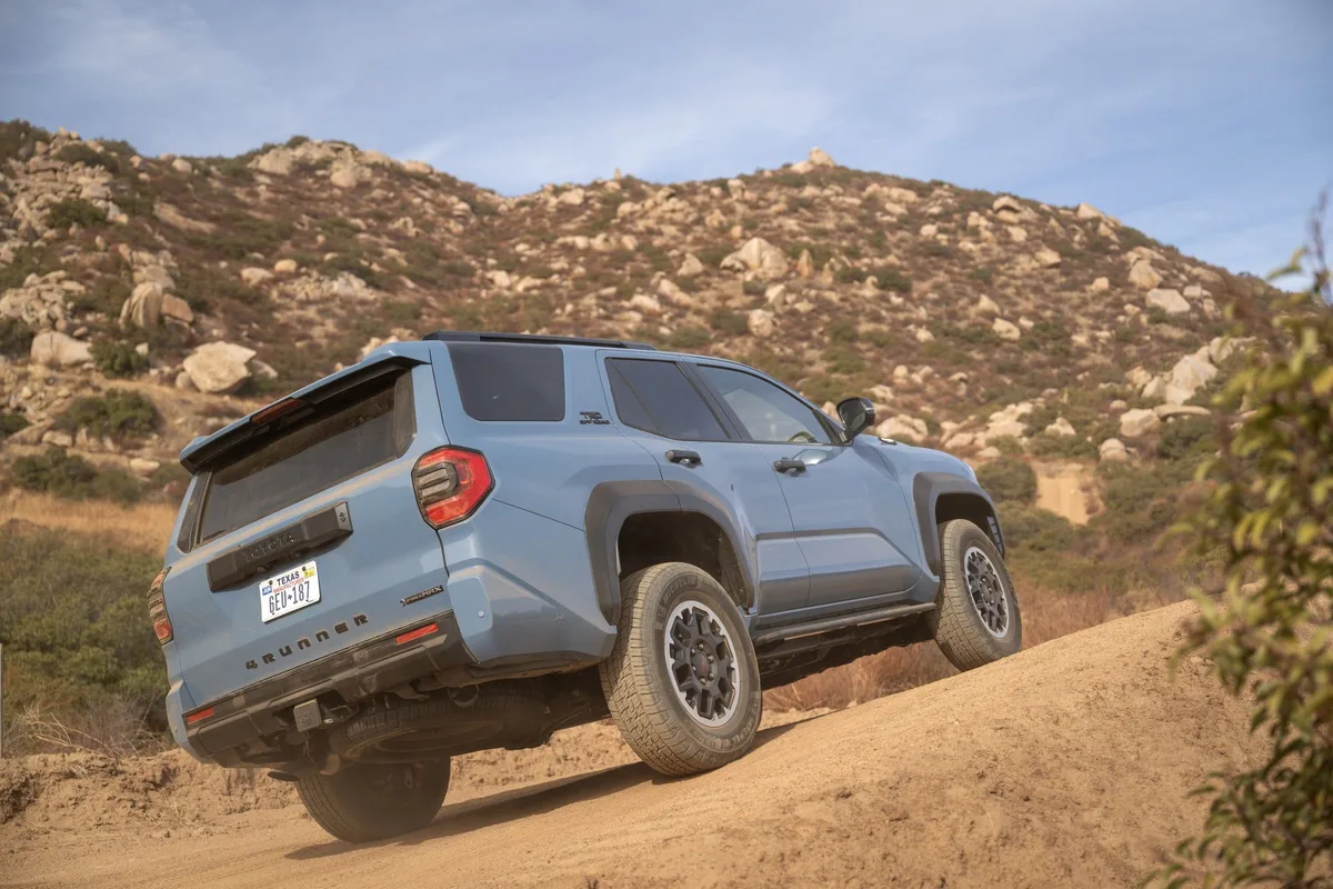 Toyota 4Runner TRD Off-Road in blue climbing a dirt trail, rear three-quarter view